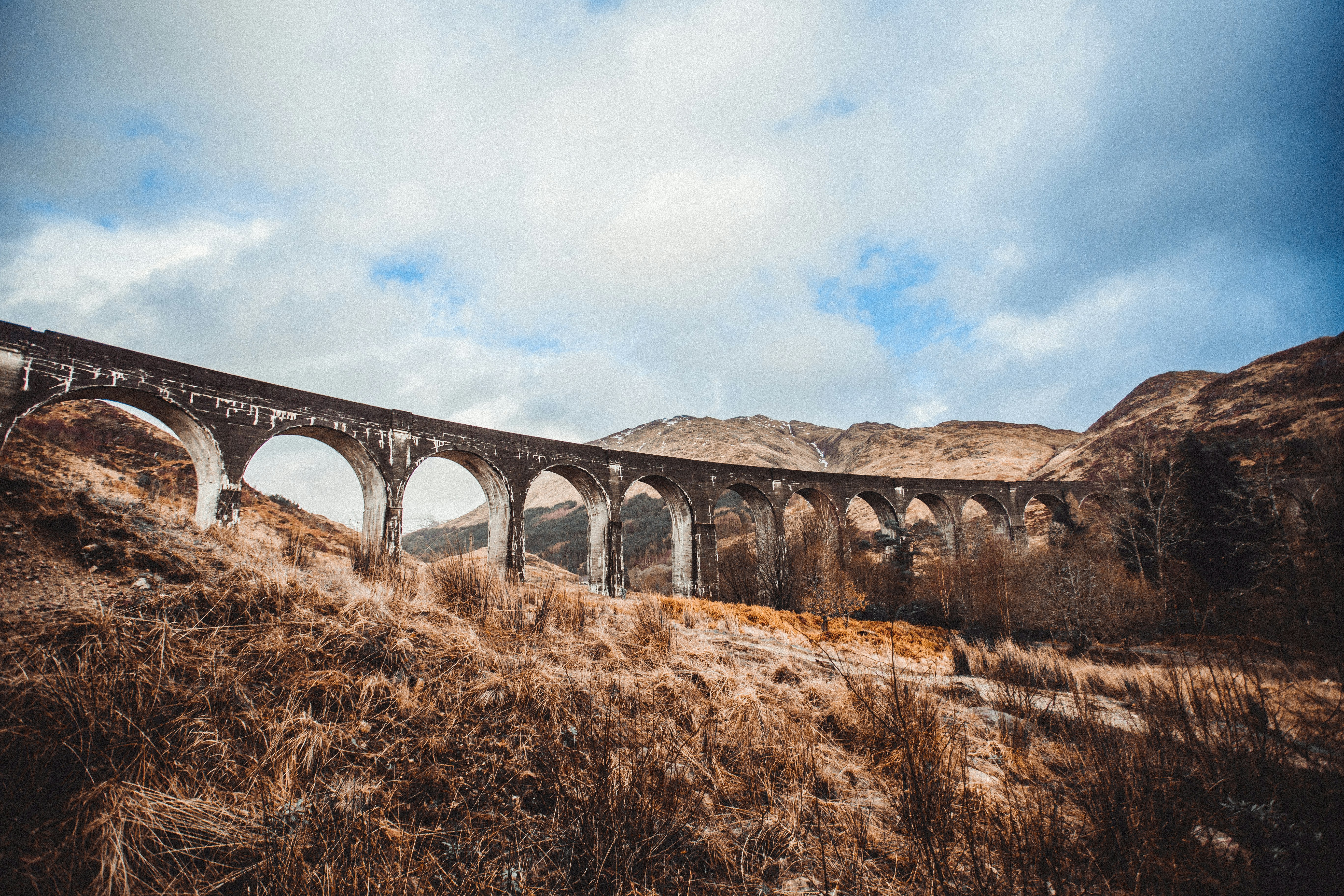 brown concrete bridge under blue sky during daytime